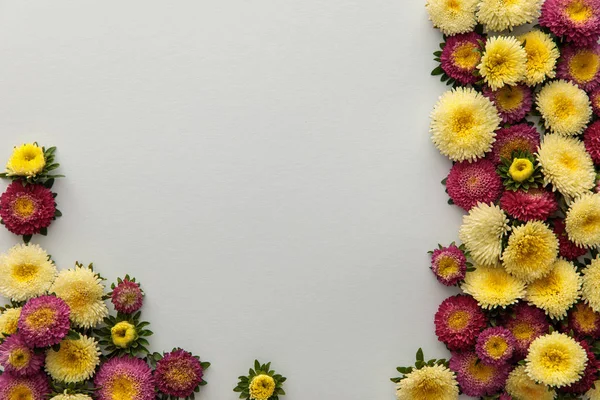 Vue de dessus des asters jaunes et violets sur fond blanc avec espace de copie — Photo de stock