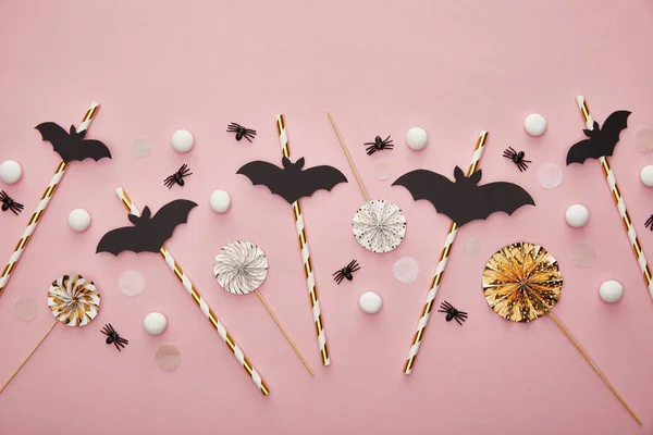 Vista superior de los murciélagos en palos sobre fondo rosa, decoración de Halloween - foto de stock