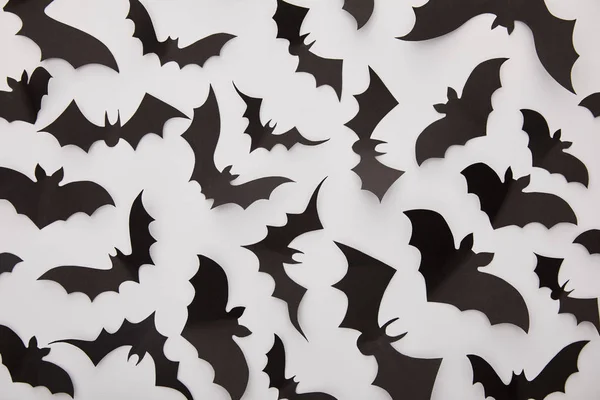 Draufsicht auf Papier schwarze Fledermäuse auf weißem Hintergrund, Halloween-Dekoration — Stockfoto