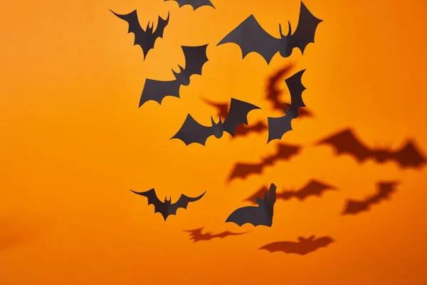 Morcegos de papel com sombra no fundo laranja, decoração de Halloween — Fotografia de Stock