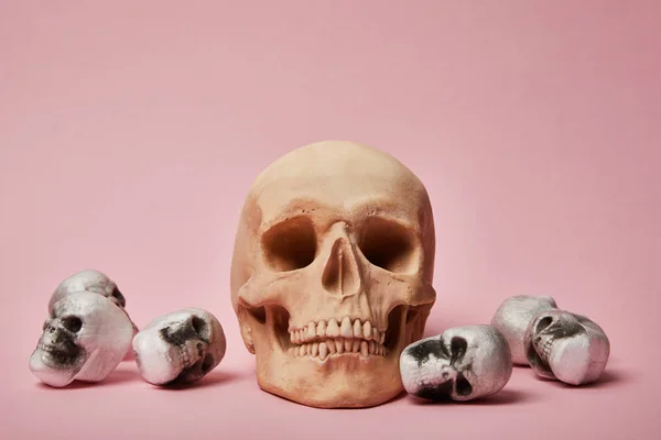 Gruselige Totenköpfe auf rosa Hintergrund, Halloween-Dekoration — Stockfoto
