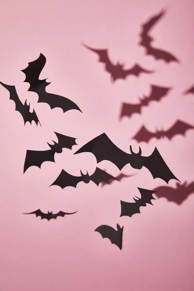 Morcegos de papel preto com sombra no fundo rosa, decoração de Halloween — Fotografia de Stock