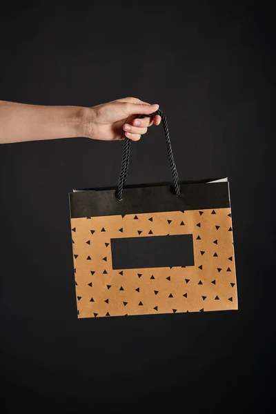 Partial view of woman holding paper shopping bags isolated on black, black Friday concept — Stock Photo