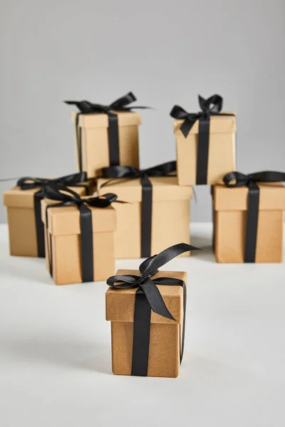 Selective focus of cardboard gift box with black ribbon isolated on grey, black Friday concept — Stock Photo