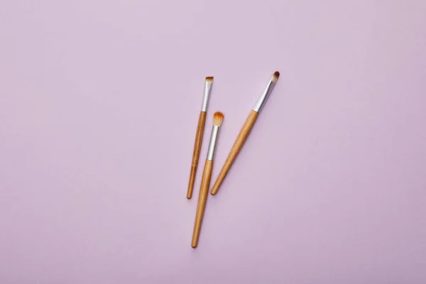 Top view of makeup brushes isolated on violet — Stock Photo