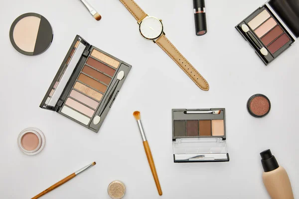 Draufsicht auf Uhr in der Nähe von dekorativer Kosmetik isoliert auf grau — Stockfoto