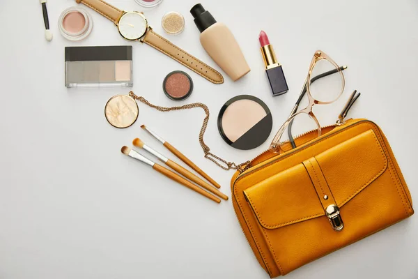 Top view of yellow bag near decorative cosmetics isolated on grey — Stock Photo