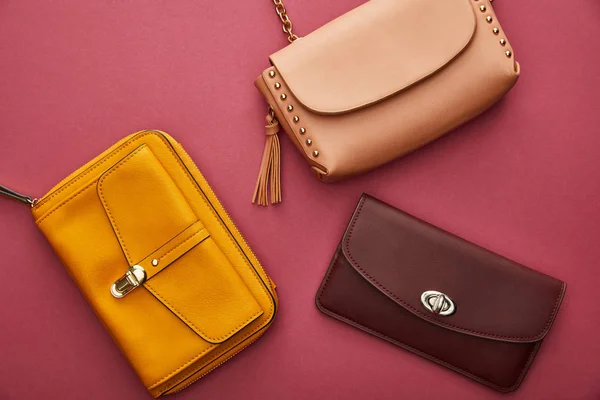 Top view of leather and stylish bags isolated on crimson — Stock Photo