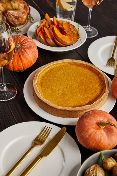 Pumpkin pie and baked pumpkins served on wooden table — Stock Photo