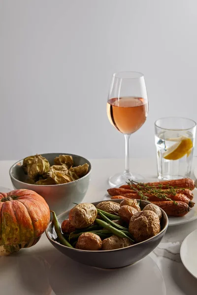 Cena festiva de acción de gracias con verduras horneadas servidas sobre una mesa de mármol aislada en gris - foto de stock