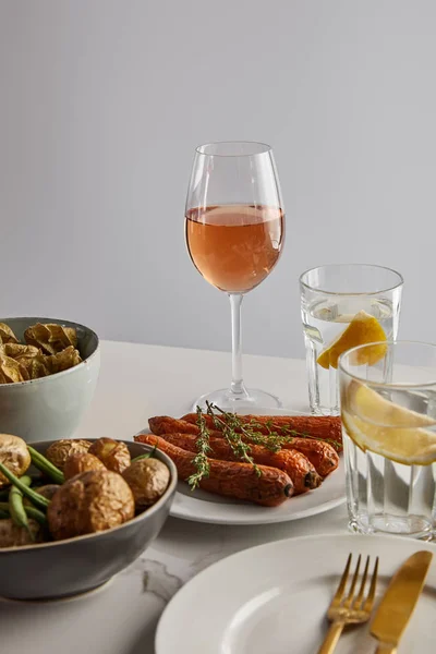 Cena festiva de acción de gracias con verduras horneadas servidas sobre una mesa de mármol aislada en gris - foto de stock