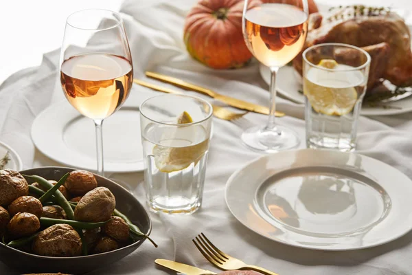 Jantar festivo de ação de graças com legumes assados, copos com vinho rosa e abóboras inteiras na mesa de mármore branco — Fotografia de Stock