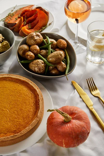 Pumkin pie, baked potato and whole pumpkin on white tablecloth isolated on grey — Stock Photo
