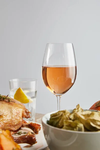 Fuoco selettivo di vetro con vino rosato vicino tacchino grigliato e physalis sostenuto isolato su grigio — Foto stock