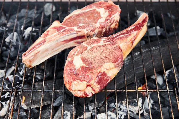 Top view of raw meat grilling on barbecue grid outside — Stock Photo