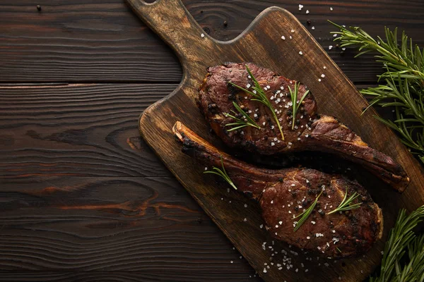 Vista superior de carne saborosa com vegetação na tábua de corte — Fotografia de Stock