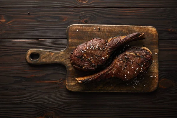 Vue de dessus de viande savoureuse avec des épices sur planche à découper — Photo de stock