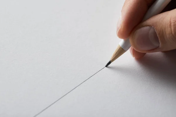 Cropped view of man drawing line on paper with pencil — Stock Photo