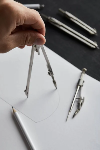 Cropped view of man drawing circle on paper with compass — Stock Photo