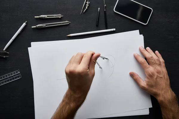 Обрезанный вид человека рисовать круг на бумаге с компасом — стоковое фото