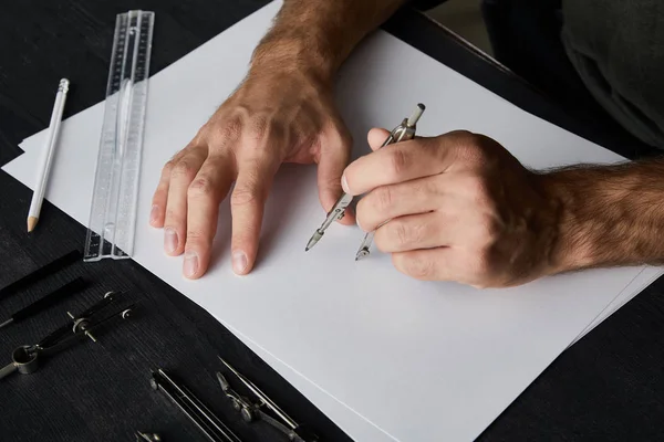 Ausgeschnittene Ansicht eines Mannes, der Kreis auf Papier mit Kompass zeichnet — Stockfoto