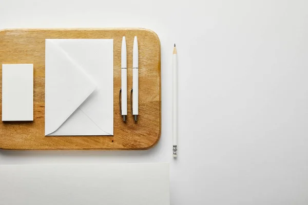 Top view of envelope, business card and pens on wooden board, pencil, paper — Stock Photo