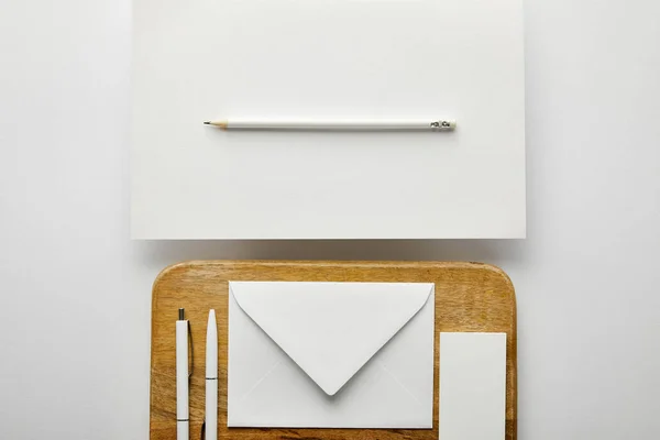 Top view of envelope, business card and pens on wooden board, pencil, paper — Stock Photo