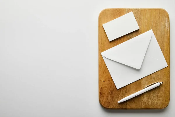 Top view of envelope, empty business card and pen on wooden board — Stock Photo