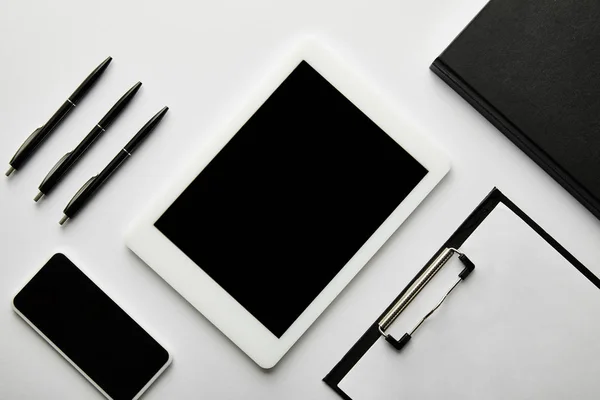 Vue du haut du presse-papiers, ordinateur portable, stylos, smartphone et tablette numérique — Photo de stock