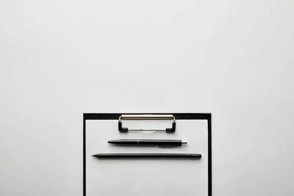 Верхний вид пустой буфер обмена, ручка и карандаш на столе — стоковое фото