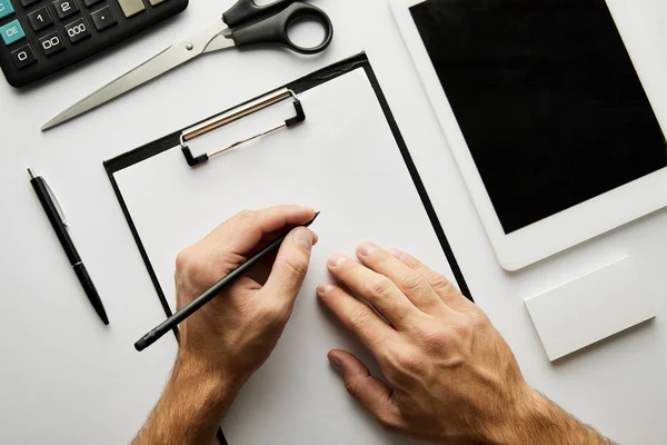 Cropped view of man writing in clipboard with pen — Stock Photo