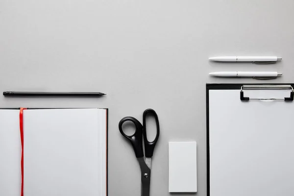 Top view of clipboard, notebook, pens, pencil and business card — Stock Photo