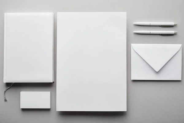 Верхний вид бумаги, ноутбука, ручки, визитная карточка и белый конверт — стоковое фото