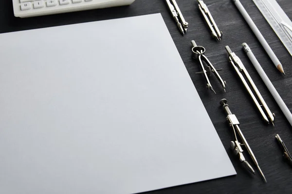 Papel blanco con espacio de copia y brújulas sobre mesa de madera y negro - foto de stock