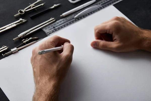 Vista recortada de hombre de negocios escribiendo sobre papel con lápiz - foto de stock