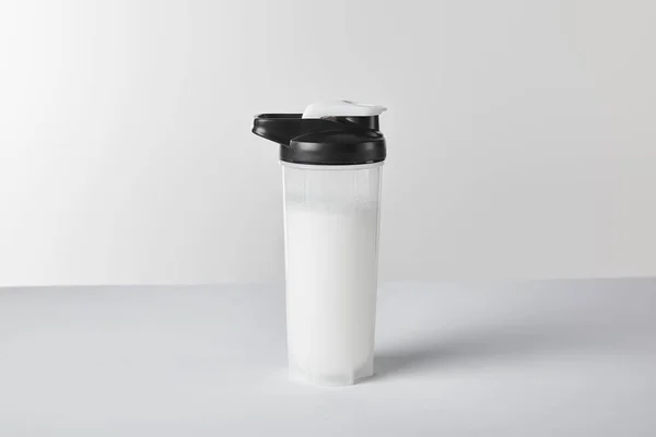 Garrafa de esportes com batido de proteína no branco — Fotografia de Stock