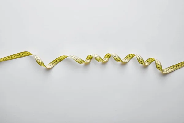 Top view of yellow measuring tape on white — Stock Photo