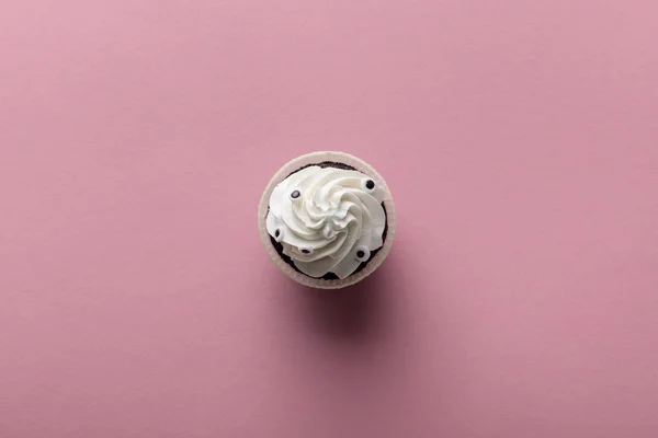 Vista superior de la deliciosa magdalena de Halloween con crema blanca sobre fondo rosa - foto de stock