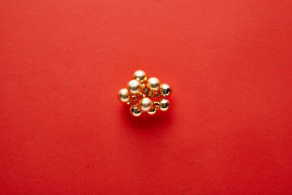 Top view of shiny golden Christmas decoration on red background with copy space — Stock Photo