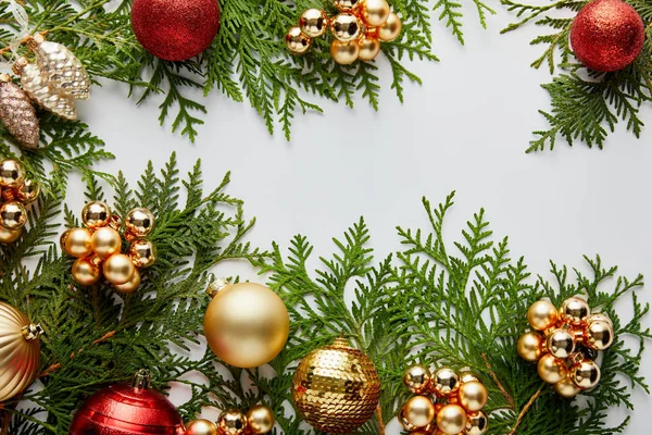 Vista superior de brillante decoración de Navidad dorada y roja en ramas de thuja verde aisladas en blanco - foto de stock