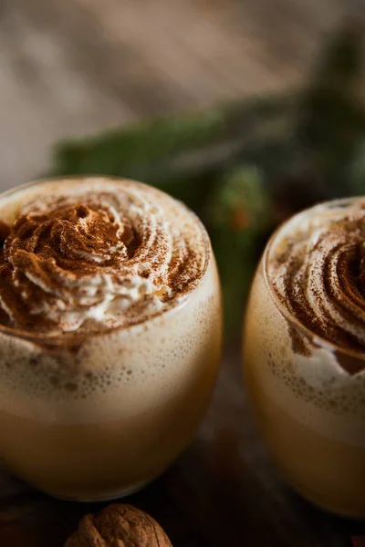 Close up view of delicious eggnog cocktail with whipped cream and cinnamon on wooden table — Stock Photo