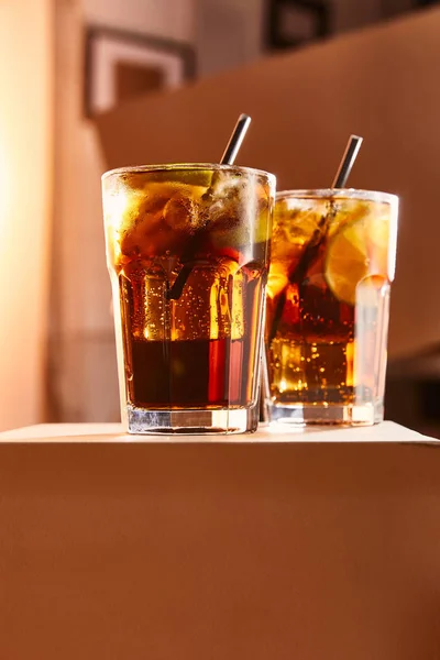Cocktails cuba libre in glasses with straws on cube — Stock Photo