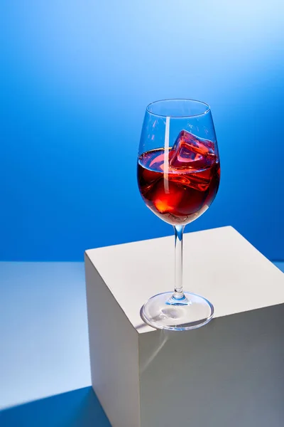 Cóctel Aperol Spritz con cubitos de hielo en vidrio sobre fondo azul - foto de stock