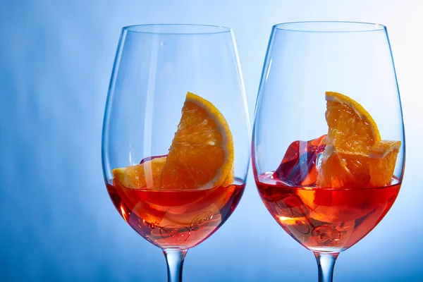 Cocktails Aperol Spritz avec glaçons dans des verres sur fond bleu — Photo de stock