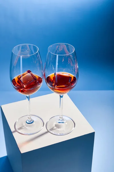 Vue grand angle des cocktails Aperol Spritz avec glaçons dans des verres sur fond bleu — Photo de stock