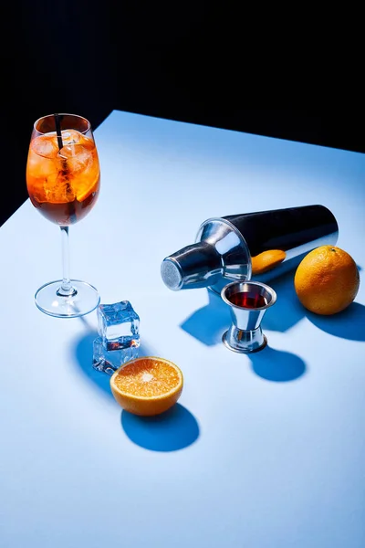 Aperol Spritz, oranges, shaker, ice cubes and measuring cup — Stock Photo