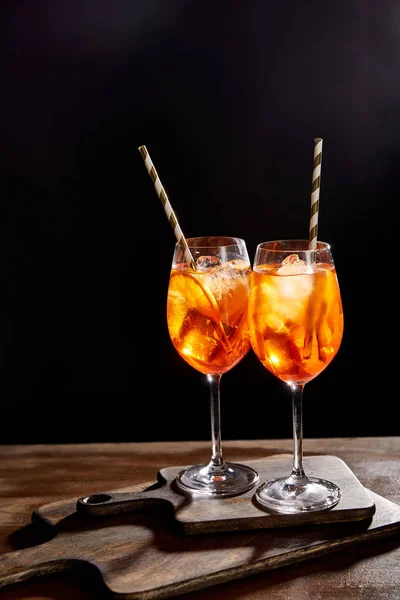 Aperol Spritz in glasses with straws on chopping boards — Stock Photo