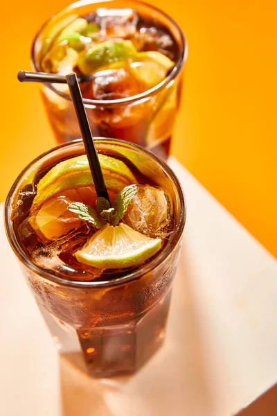 Selektiver Fokus von Cocktail cuba libre im Glas mit Stroh auf Würfel — Stockfoto