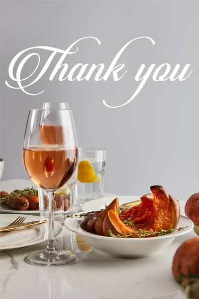Gläser mit Rosenwein, gebackenem Kürbis und Möhren serviert auf weißem Marmortisch isoliert auf grau mit Danksagung Illustration — Stockfoto