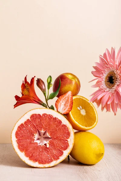 Floral and fruit composition with gerbera, Alstroemeria, citrus fruits, strawberry and peach on beige background — Stock Photo